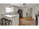 Eat-in kitchen featuring white cabinets, black appliances, island with sink, and wood flooring at 4345 Elkhorn Dr, Westfield, IN 46062