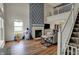 Cozy living room with a fireplace, large window, and staircase leading to a second-floor balcony at 4345 Elkhorn Dr, Westfield, IN 46062