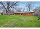The backyard has a brick ranch-style home with a large, green lawn and mature trees at 4601 N Ball Ave, Muncie, IN 47304