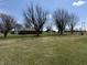 Scenic backyard featuring a brick house, and a charming outbuilding surrounded by mature trees at 4611 E Us Highway 36, Markleville, IN 46056