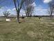 The backyard features a well-maintained lawn with scattered trees and charming outbuildings at 4611 E Us Highway 36, Markleville, IN 46056