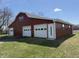 Red barn with three garage doors and side entry at 4611 E Us Highway 36, Markleville, IN 46056