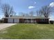 Inviting front exterior of brick home with attached garages and a well-manicured green lawn at 4611 E Us Highway 36, Markleville, IN 46056