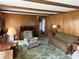 Cozy living room featuring wood paneling, vintage furniture, and warm, inviting lighting at 4611 E Us Highway 36, Markleville, IN 46056