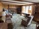 Comfortable living room featuring wood paneling, a brick fireplace, and ample seating for relaxation at 4611 E Us Highway 36, Markleville, IN 46056