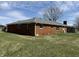 Rear exterior featuring brick facade, neatly trimmed lawn, and windows overlooking the backyard at 4611 E Us Highway 36, Markleville, IN 46056