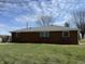 Back exterior shot showcasing a brick home with a well-maintained yard and clear sky backdrop at 4611 E Us Highway 36, Markleville, IN 46056