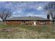 The rear exterior showing the brick house with a fire pit and a well-manicured lawn at 4611 E Us Highway 36, Markleville, IN 46056