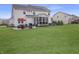 Spacious backyard with a well-maintained lawn, patio furniture and screened in porch at 4733 Mecklenburg Dr, Plainfield, IN 46168