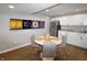 A modern kitchenette features white cabinets, stainless steel appliances, and a cozy dining area with colorful artwork at 4733 Mecklenburg Dr, Plainfield, IN 46168