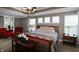 Spacious main bedroom with a wooden bed frame, ample natural light, and comfortable seating area at 4733 Mecklenburg Dr, Plainfield, IN 46168