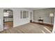 Spacious living area featuring a brick wall accent, light carpet, and an archway leading to an adjoining room at 4906 S State Ave, Indianapolis, IN 46227