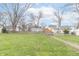 View of the backyard showing a large lawn, wooden fence, and storage shed under a blue sky at 508 Mount St, Greenfield, IN 46140