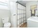 Cozy bathroom featuring a toilet, vanity, and tiled shower area with a decorative curtain at 508 Mount St, Greenfield, IN 46140