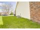 Side yard featuring a well-maintained lawn, brick accents, and functional utilities at 5417 Kerns Ln, Indianapolis, IN 46268