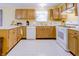 Traditional kitchen featuring wood cabinets, white appliances, and tile flooring, great for Gathering meals at 5417 Kerns Ln, Indianapolis, IN 46268