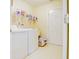 A functional laundry room featuring a washer, dryer, storage shelving, and tile flooring for easy maintenance at 5417 Kerns Ln, Indianapolis, IN 46268