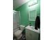 Bathroom featuring a vanity, toilet, and shower-tub combo with a glass door at 5707 W Mills Rd, Indianapolis, IN 46221