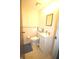 Cozy half bathroom features a pedestal sink and toilet with patterned wallpaper and linoleum flooring at 5707 W Mills Rd, Indianapolis, IN 46221