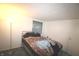 Simple bedroom with a metal bedframe, window, and a neutral-toned color scheme, offering a tranquil personal space at 5707 W Mills Rd, Indianapolis, IN 46221