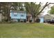 Charming light blue split-level home with attached garage and mature landscaping in a quiet neighborhood at 5707 W Mills Rd, Indianapolis, IN 46221