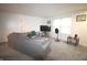 Bright living room with neutral carpet, modern lighting, a large sectional sofa, and a TV at 5707 W Mills Rd, Indianapolis, IN 46221