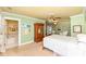 Bright bedroom featuring a ceiling fan, armoire, and an ensuite bathroom with a tub at 5718 E Pleasant Run Parkway North Dr, Indianapolis, IN 46219