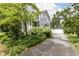 Beautifully landscaped side yard and driveway leading to a detached garage, adding to the home's charm at 5718 E Pleasant Run Parkway North Dr, Indianapolis, IN 46219