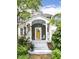 Inviting front porch with a bright yellow door, decorative columns, and well-maintained landscaping at 5718 E Pleasant Run Parkway North Dr, Indianapolis, IN 46219