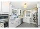 Bright kitchen with white cabinets, patterned tile flooring, and modern appliances at 5718 E Pleasant Run Parkway North Dr, Indianapolis, IN 46219