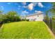 Large backyard with lush green grass and a black metal fence surrounding the property, offering ample space at 5989 Ashmore Ln, Carmel, IN 46033
