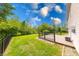 Expansive backyard featuring a wooden deck, green lawn, and a wrought iron fence under a sunny sky at 5989 Ashmore Ln, Carmel, IN 46033