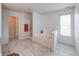 Airy bathroom with a large tub, white tile floors, and natural light, creating a serene and inviting space at 5989 Ashmore Ln, Carmel, IN 46033