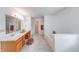 Bright bathroom featuring a soaking tub, wood cabinets, and a large vanity, perfect for relaxation and organization at 5989 Ashmore Ln, Carmel, IN 46033