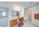 Well-lit bathroom featuring a vanity with wood cabinetry, a large mirror, and white tile flooring at 5989 Ashmore Ln, Carmel, IN 46033