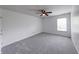 Cozy bedroom with neutral carpet, ceiling fan, and a window providing natural light at 5989 Ashmore Ln, Carmel, IN 46033