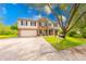 Two-story home with brick and vinyl siding, an attached garage, and a well-maintained lawn with a long concrete driveway at 5989 Ashmore Ln, Carmel, IN 46033