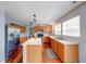 Well-lit kitchen with stainless steel appliances, island, and wooden cabinetry at 5989 Ashmore Ln, Carmel, IN 46033