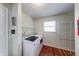 Bright laundry room with washer, dryer, and shelving for ample storage solutions at 5989 Ashmore Ln, Carmel, IN 46033