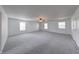 Bright and airy living room with soft carpet, ceiling fan, and multiple windows offering plenty of natural light at 5989 Ashmore Ln, Carmel, IN 46033