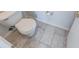 Close-up shot of a toilet and floor with tile, with a door on the right side at 5989 Ashmore Ln, Carmel, IN 46033