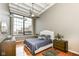 Bedroom with large window, ceiling fan, hardwood floors, and stylish decor at 624 E Walnut St # 21, Indianapolis, IN 46204