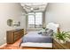 Bedroom with large window, ceiling fan, hardwood floors, and stylish decor at 624 E Walnut St # 21, Indianapolis, IN 46204