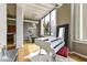 Bright living area boasts a white piano, high ceilings, and large windows with city views at 624 E Walnut St # 21, Indianapolis, IN 46204