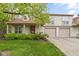 Inviting two-story home features a well-maintained lawn, beautiful greenery, and a charming red door at 6404 Bayside Ct, Indianapolis, IN 46250