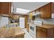 Well-lit kitchen features wooden cabinetry, white appliances, and tile flooring at 6404 Bayside Ct, Indianapolis, IN 46250