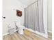 Bathroom with a toilet, shower with curtain, and wood-look floors at 6413 N Wheeling Ave, Muncie, IN 47304