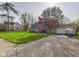Inviting brick home features a long driveway, green lawn, and attached two-car garage at 6413 N Wheeling Ave, Muncie, IN 47304