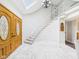 Bright foyer features stone flooring, an elegant staircase, and a skylight at 6413 N Wheeling Ave, Muncie, IN 47304