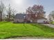 Charming brick home boasts a lush front yard and attached two-car garage at 6413 N Wheeling Ave, Muncie, IN 47304